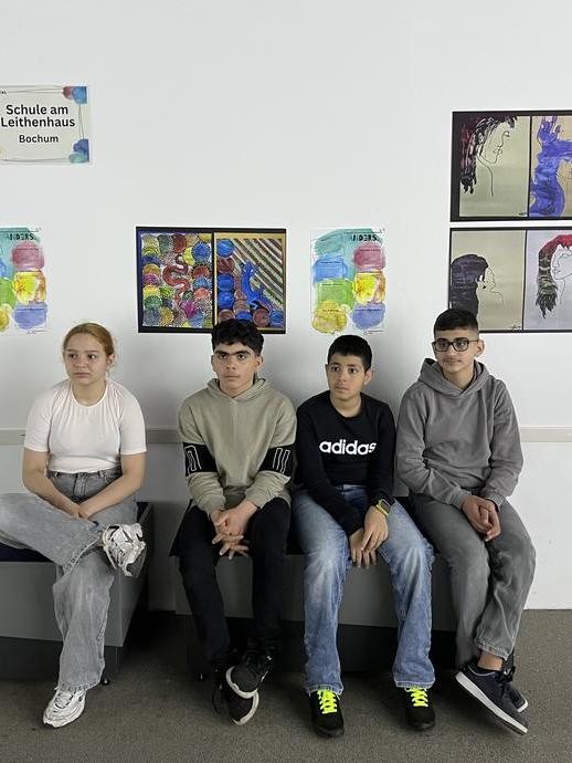 Bank mit Schüler:innen (vergrößerte Bildansicht wird geöffnet)