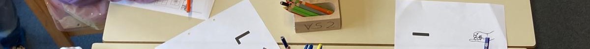Schüler sitzen am Tisch und arbeiten.