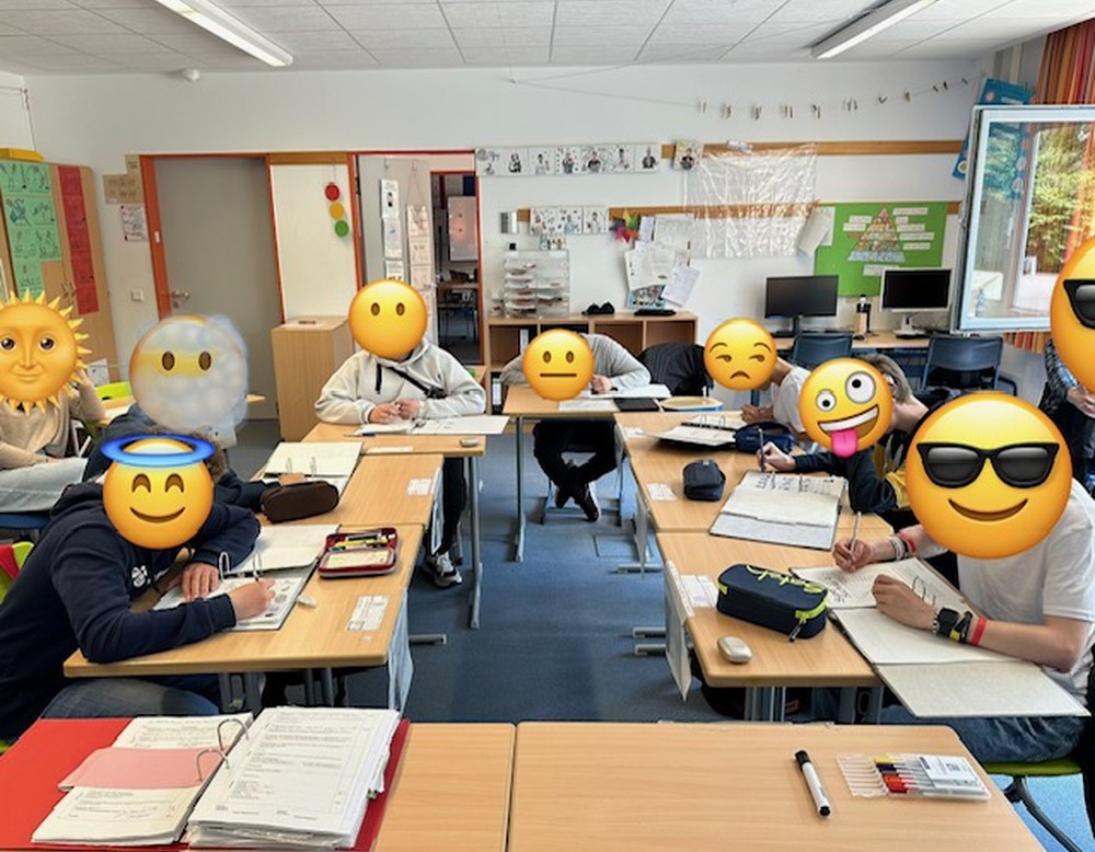 Schüler:innen sitzen an ihren Tischen und arbeiten.