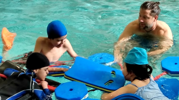 Lehrer mit Schüler:innen im Wasser